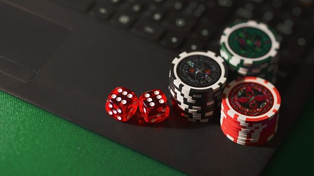 Online-Glücksspiel mit einem Laptop mit Würfeln und Chips